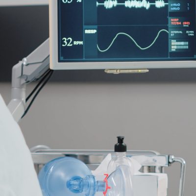 Close up of heart rate monitor in empty hospital ward. Nobody in intensive care room with medical equipment, bed, oxygen tube and wheelchair for recovery. Healthcare instruments